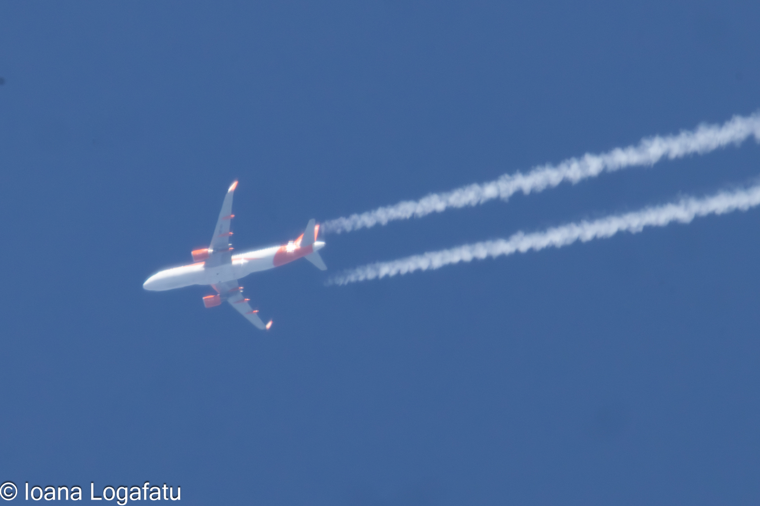 An aircraft glides high above clouds
